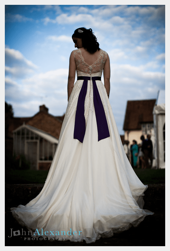 Ivory silk and lace wedding dress by Felicity Westmacott: purple sash