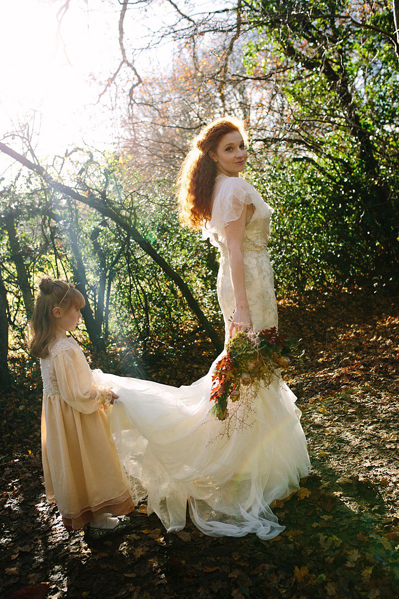 flowergirl with bride holding train rosegold chiffon and beaded lace