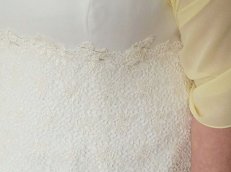 guipure lace pinned to ivory silk on a made to measure wedding gown, fitting