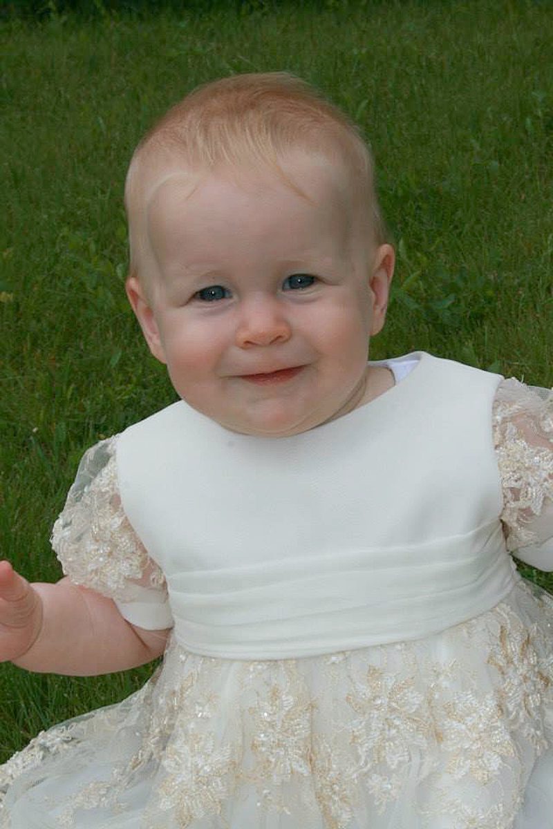 traditional christening gown with pleated chiffon sash on seated baby