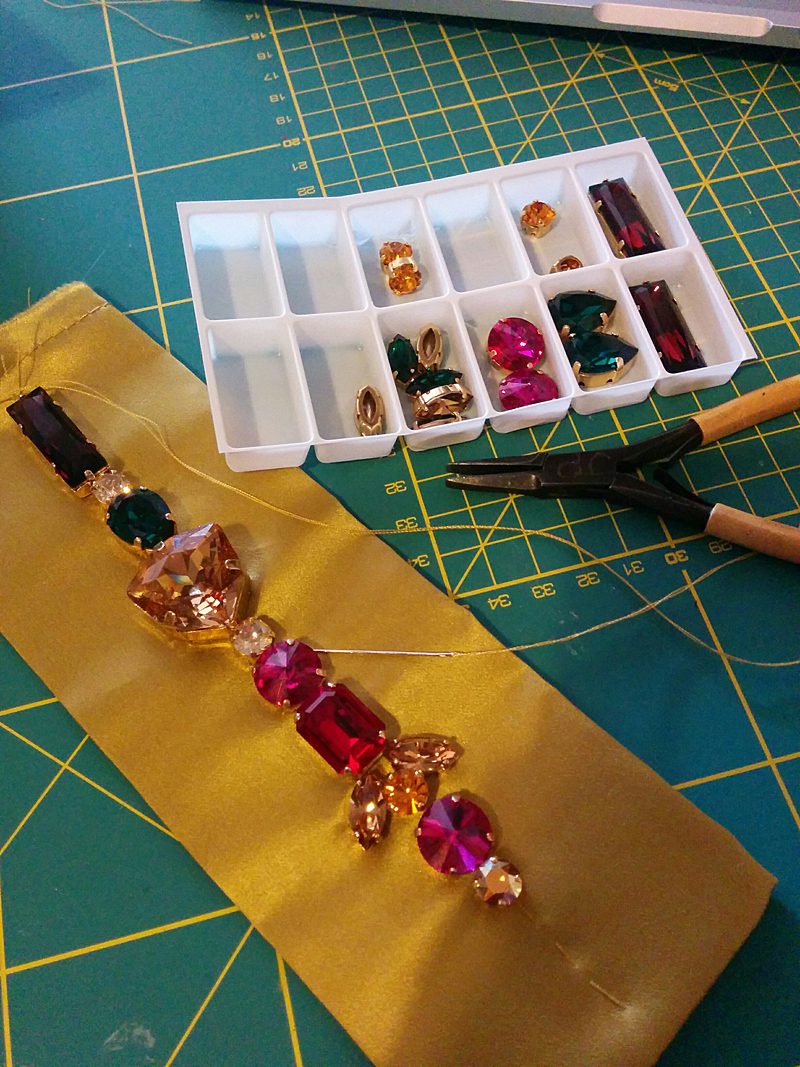 on the work room table hand beading chunky jewels red cerise pink yellow green