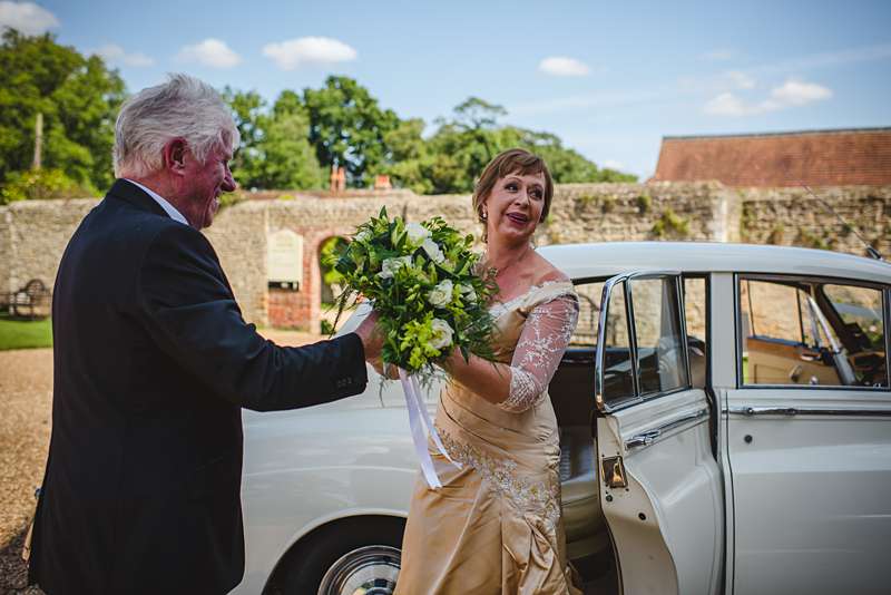 mature bride arrived in car gold wedding dress