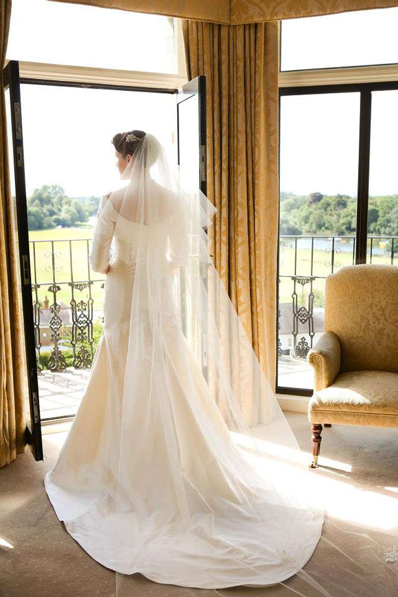 graceful window lit bride with veil and train