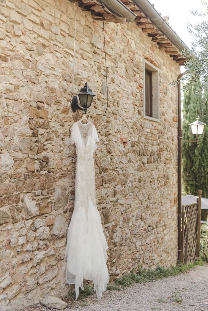 rustic wedding dress against old stone wall