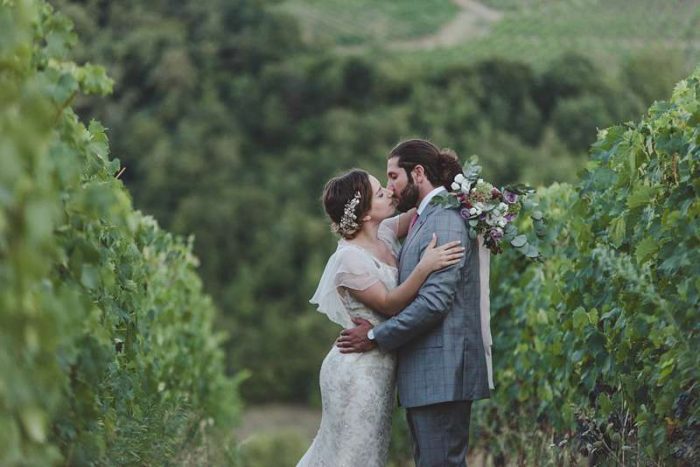 romantic kiss in a bespoke silver wedding dress with sleeves