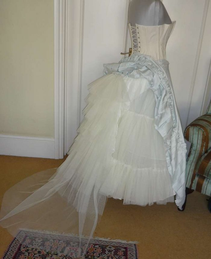 underpinnings for victorian wedding dress with net bustle and train support on the stand side view