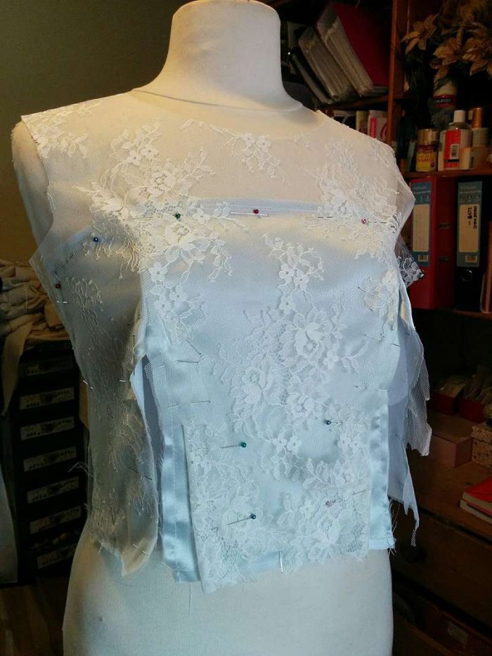 couture techniques: pinning on the lace to bodice with the partly made dress on the stand