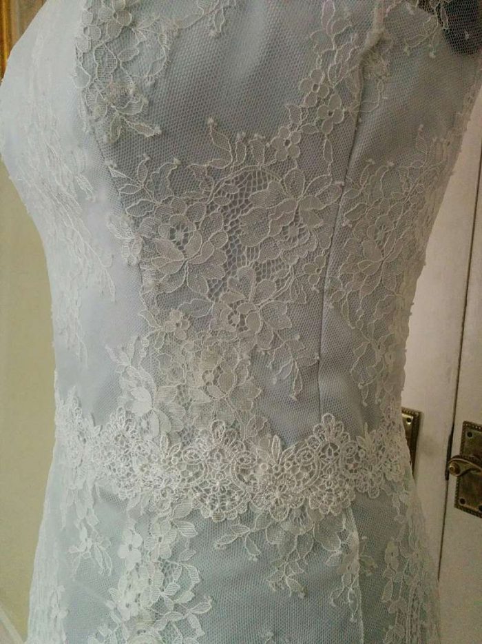 detail of finished chantilly wedding dress on the stand with lace