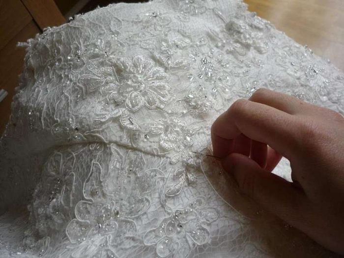 sewing beads and pearls onto lace by hand