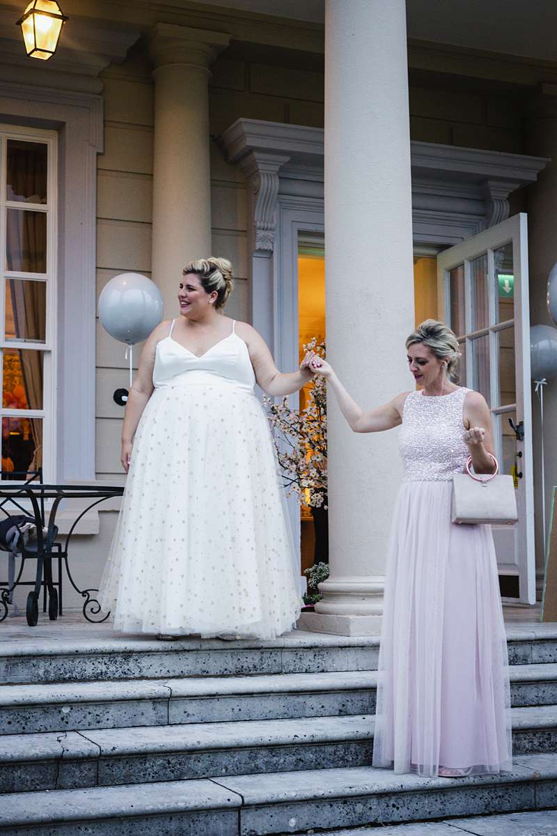 bride in ivory plus size reception dress with her sister