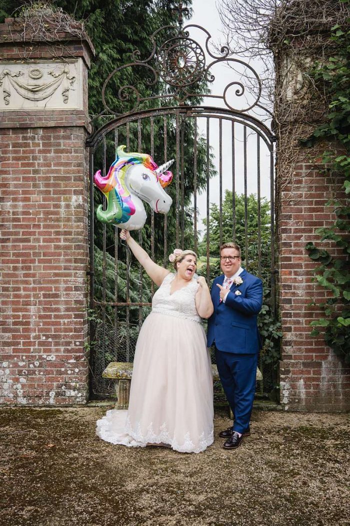 bride and groomwith helium balloon in front of metal gates