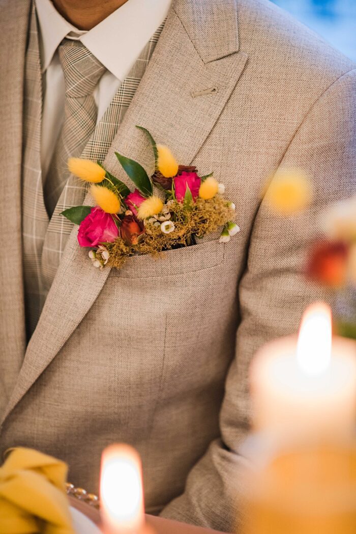 pink and yellow floral buttonhole in pocket