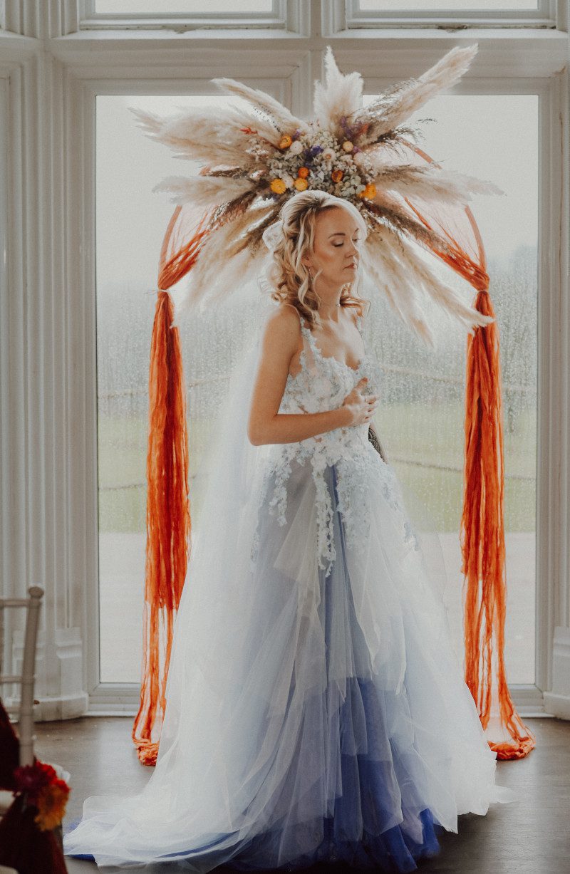 light pale bright blue layered tiered tulle wedding dress floral details wisteria inspired arch