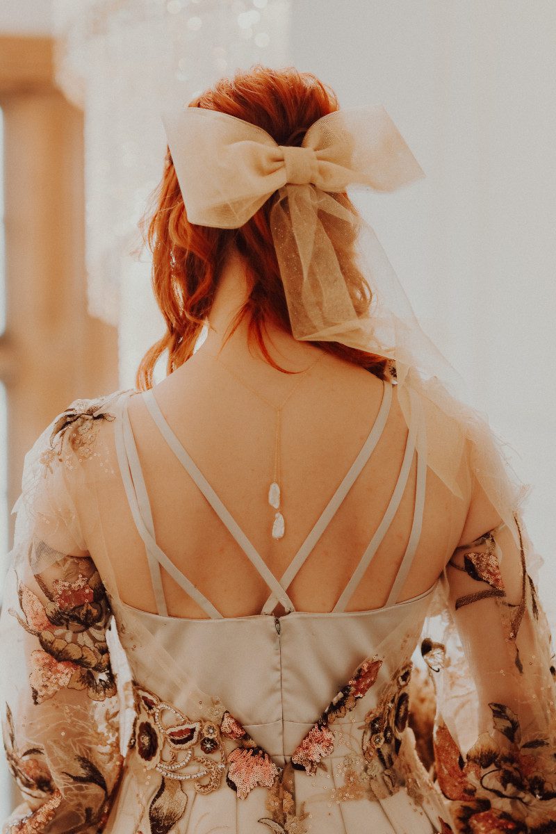 strappy wedding dress low back sheer sequin overlay matching hair bow witchy crystal back necklace