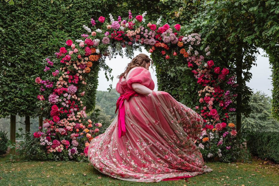 floral pretty pink cerise fuchsia wedding dress dramatic princess skirt swoosh flower arch