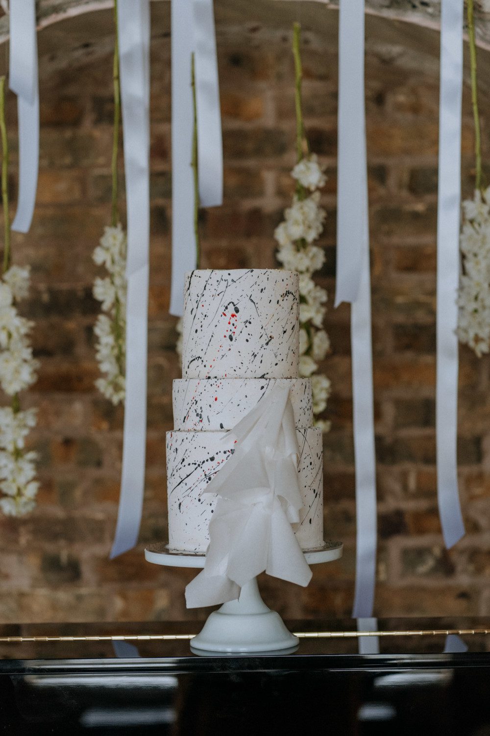 simple minimalist white red black paint splatter origami inspired wedding cake