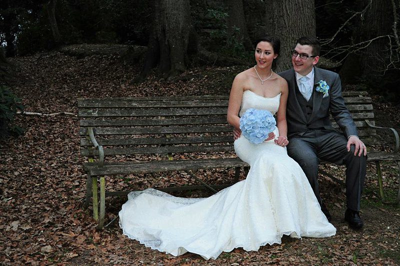 chapel train fitted wedding dress seated on a bench