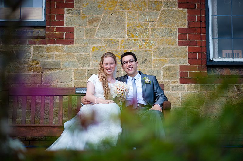 bride and groom on bench