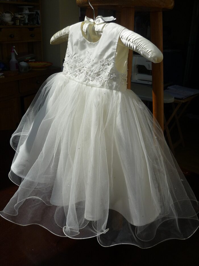 Custom mini-me christening dress on a hanger