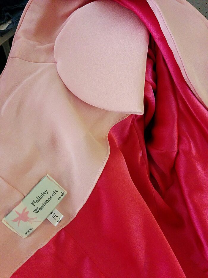 inside detail of Felicity Westmacott label, cerise pink silk lining and covered shoulder pad in bespoke jacket